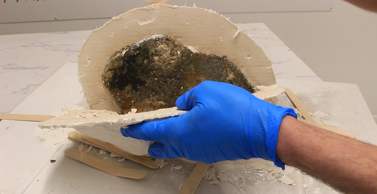 Releasing the first half of the mould from the rock. 